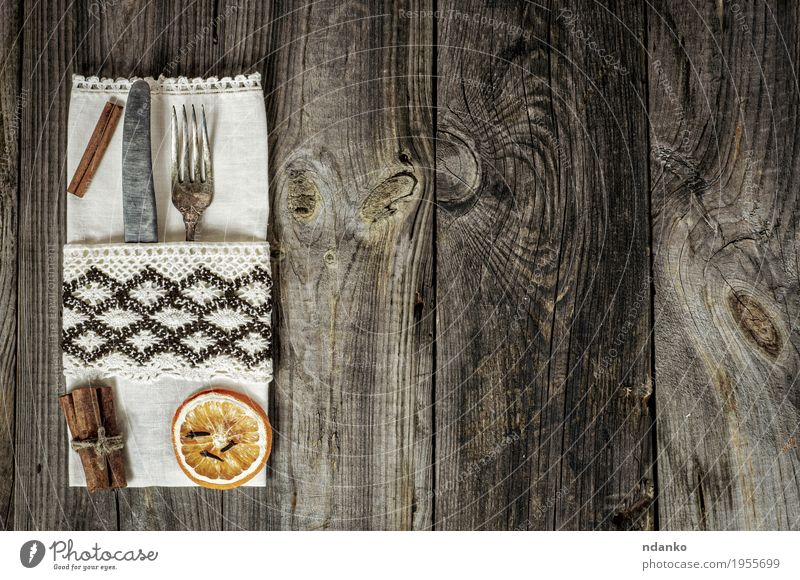 Metallgeräte verziert mit einer Serviette auf einer grauen Holzoberfläche Mittagessen Abendessen Besteck Messer Gabel Tisch Küche Restaurant Stahl alt oben