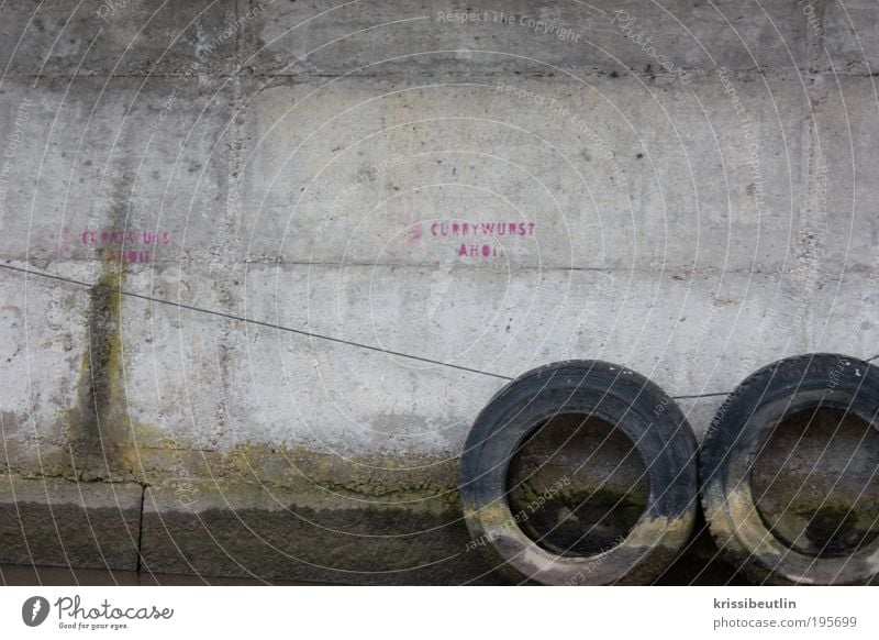 Currywurst I Mauer Wand Autoreifen Reifen Hafenmauer Stein Beton Graffiti entdecken Ferien & Urlaub & Reisen dreckig lustig trist grau rosa Rätsel skurril