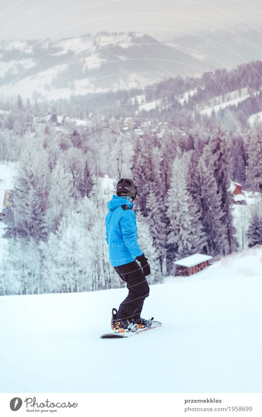 Junge, der einen Snowboard den Abhang hinunter reitet Lifestyle Freude Ferien & Urlaub & Reisen Winter Schnee Winterurlaub Berge u. Gebirge Sport Natur