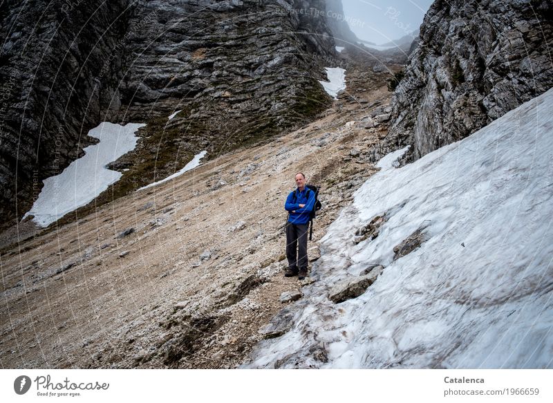 Wanderer im Gebirge am Schneefeld Winter Berge u. Gebirge wandern maskulin Mann Erwachsene 1 Mensch Landschaft Frühling schlechtes Wetter Nebel Felsen Alpen