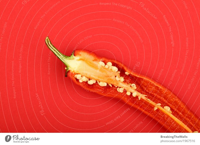 Frischer scharfer Paprikapfeffer nah oben auf rotem Papierhintergrund Gemüse Kunst frisch heiß schön natürlich Farbe Hälfte eine geschnitten Hintergrund erhöht