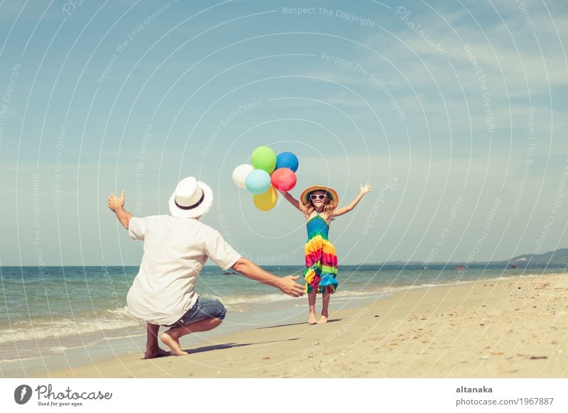 Vater und Tochter mit den Ballonen, die auf dem Strand spielen Lifestyle Freude Leben Erholung Freizeit & Hobby Spielen Ferien & Urlaub & Reisen Ausflug