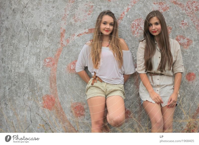 2 Mädchen, die gegen eine Wand stehen und für die Kamera aufwerfen Lifestyle Stil schön Körper Haare & Frisuren Wellness Leben harmonisch Wohlgefühl
