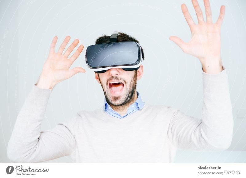 Mann mit VR-Brille erschreckt und hebt die Hände Freude virtuell virtuelle realität Wissenschaften Medienbranche Werbebranche Telekommunikation Computerspiel