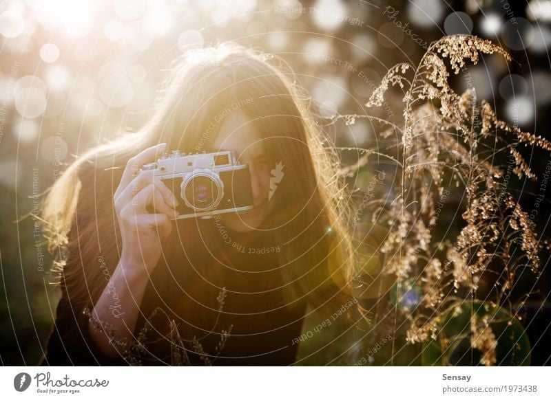 junges Mädchen, das Foto im Park macht Lifestyle Freude schön Haut Gesicht Sommer Fotokamera Mensch Frau Erwachsene Natur Herbst Blume Mode Lächeln Erotik retro