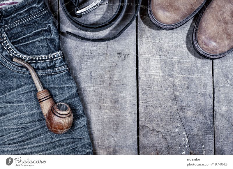 Hölzernes Rohr für das Rauchen auf Blue Jeans Bekleidung Arbeitsbekleidung Hose Jeanshose Leder Schuhe Stiefel alt oben retro blau grau schwarz Röhren Tabak