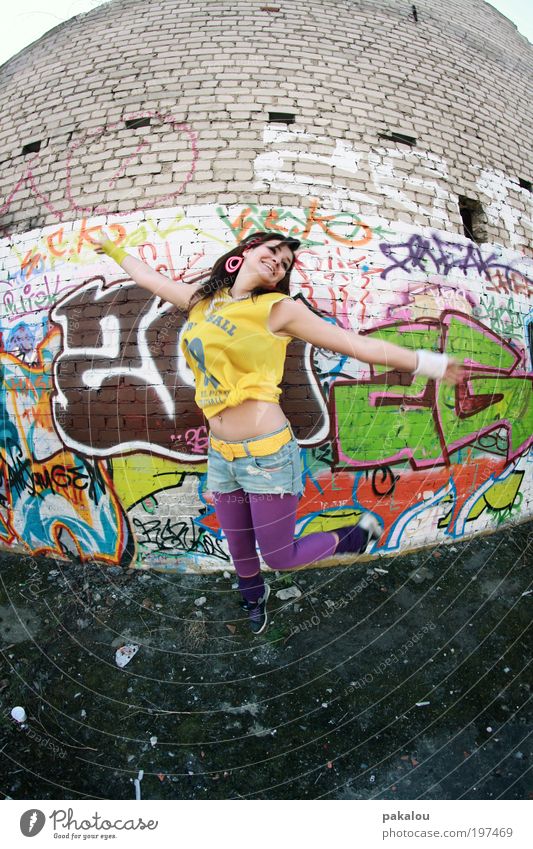 buntes kommt aus der mitte Lifestyle Freude Tanzen feminin Frau Erwachsene 18-30 Jahre Jugendliche Stadt Mauer Wand Mode Jeanshose Graffiti Lächeln lachen
