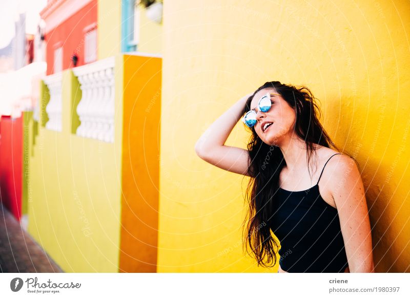 Portrait der kaukasischen Frauen, die vor gelber Wand stehen Lifestyle Glück Sommer Haus feminin Junge Frau Jugendliche Erwachsene Sonnenbrille brünett