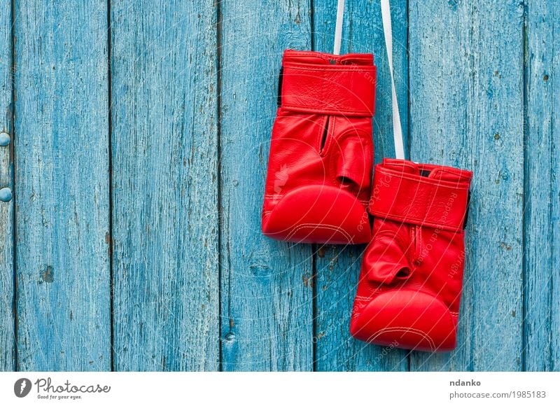Paar rote Boxhandschuhe, die an einem Nagel hängen Sport Sportveranstaltung Erfolg Handschuhe Holz retro blau Konkurrenz Objektfotografie Kick Kopie Kraft
