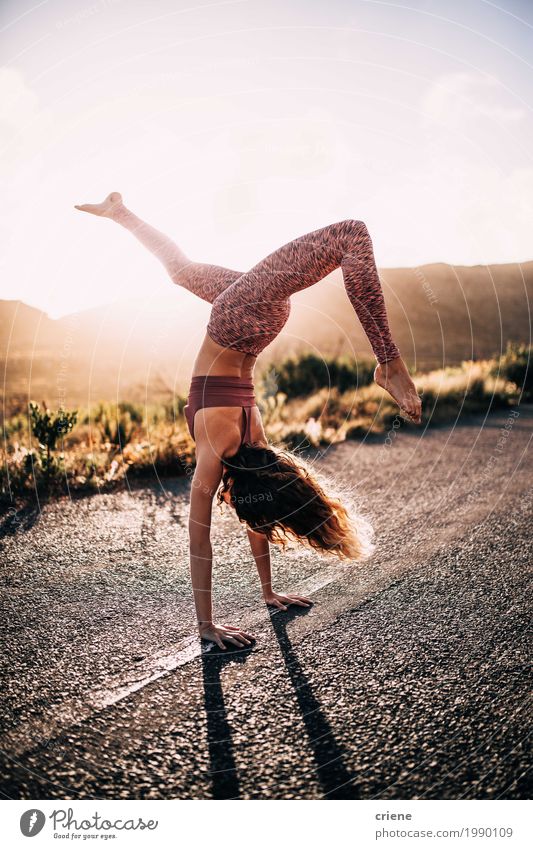 Junge kaukasische Frau, die Yoga auf Straße im Sonnenuntergang tut Lifestyle Freude Glück Freizeit & Hobby Ausflug Abenteuer Sommer Sommerurlaub Sport feminin