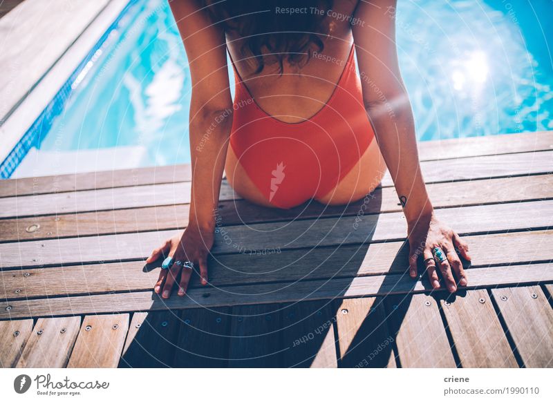 Hintere Ansicht der Frau sitzend am Swimmingpool in der Badebekleidung Lifestyle Freude Erholung Spa Schwimmbad Ferien & Urlaub & Reisen Sommer feminin