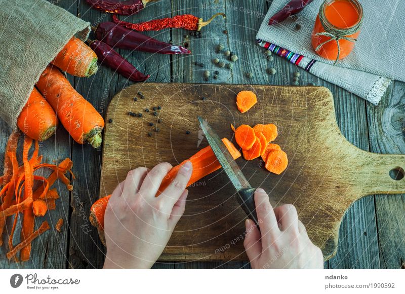 Geschnittene frische Karotten auf einem Küchenbrett Gemüse Kräuter & Gewürze Vegetarische Ernährung Diät Getränk Saft Messer Tisch Frau Erwachsene Hand Finger 1