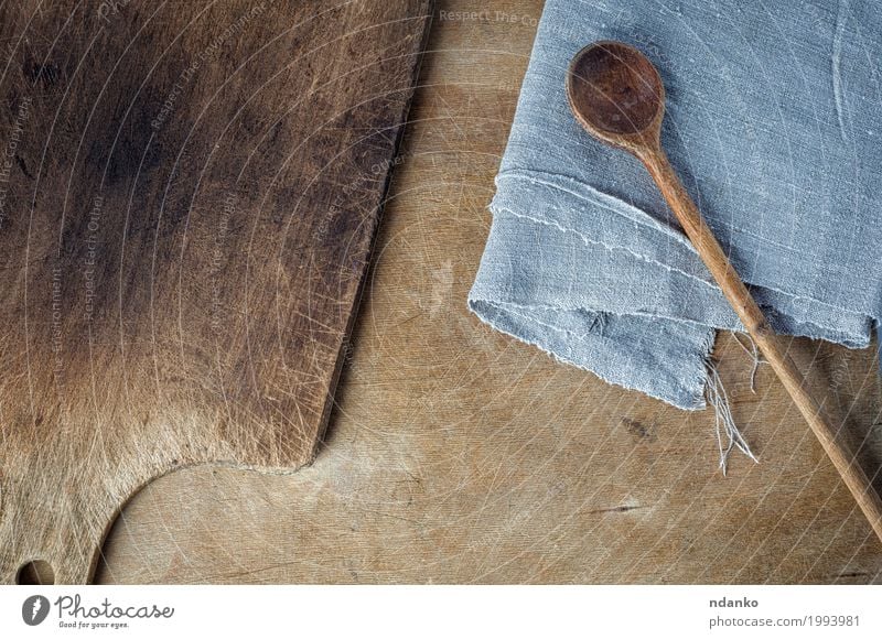 Schneidebrett und ein Holzlöffel auf dem Tisch Löffel Küche Kochlöffel alt oben braun grau Holzplatte Leerraum Hintergrund schäbig Haushaltswaren heimwärts