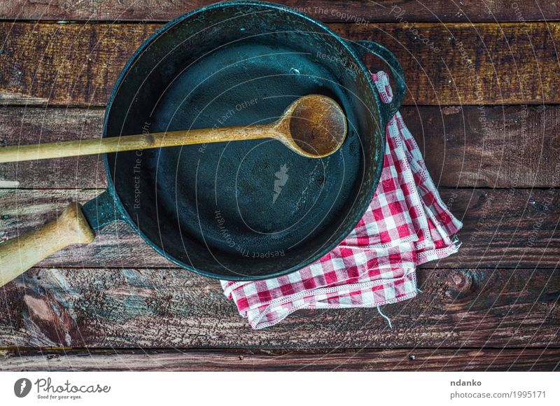 leere schwarze Gusseisenbratpfanne Geschirr Pfanne Löffel Design Tisch Küche Restaurant Stoff Holz Metall oben Sauberkeit braun Tischwäsche Spachtel Aussicht