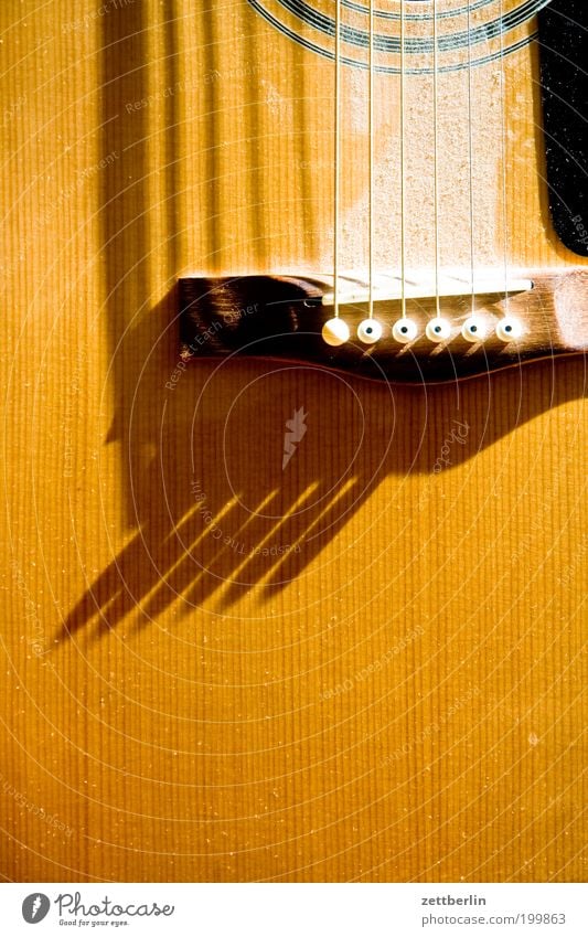 Helle Gitarre Musik Musikinstrument Saite Saiteninstrumente Staub Licht Schatten Holz akustisch Nahaufnahme gelb
