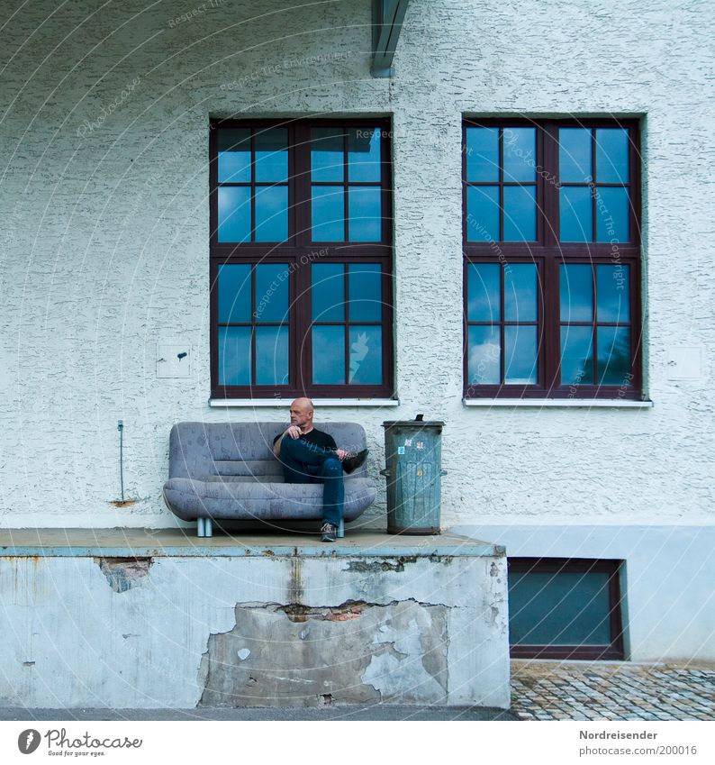 Mann auf einer Couch vor einer Fassade Lifestyle Stil Design Häusliches Leben Möbel Sofa Feierabend maskulin Erwachsene 1 Mensch 45-60 Jahre Mauer Wand Glatze