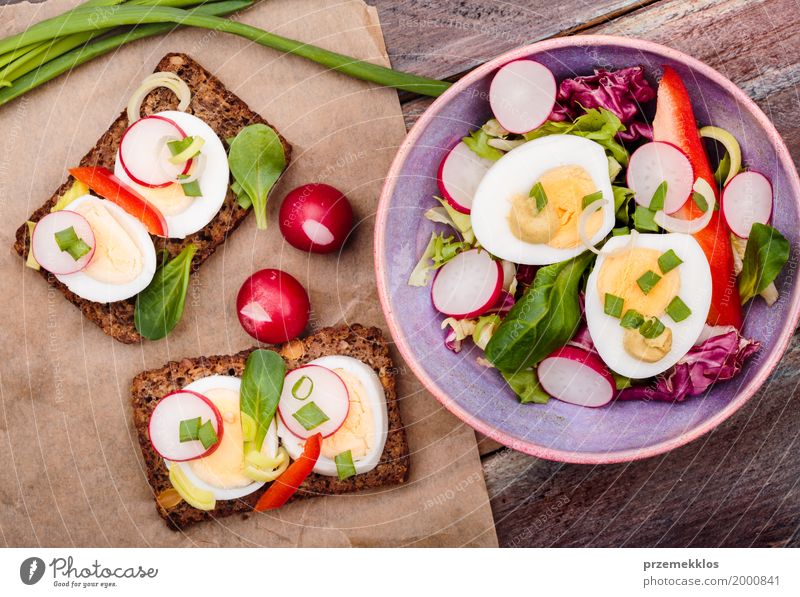 Gesunde Mahlzeit mit Eiern und Gemüse Lebensmittel Salat Salatbeilage Brot Mittagessen Vegetarische Ernährung Diät Schalen & Schüsseln Tisch Holz frisch
