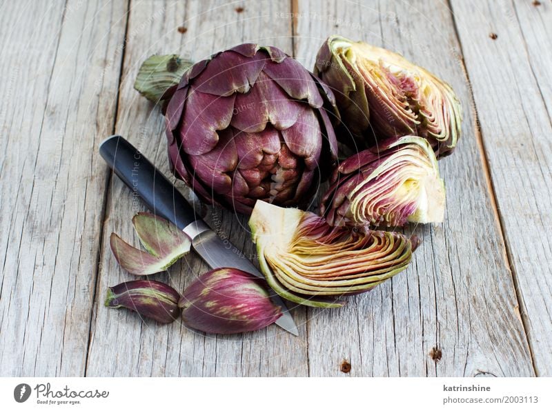 Römische Artischocken auf einem Holzbrett mit Messer Gemüse Ernährung Vegetarische Ernährung Italienische Küche frisch grau grün Ackerbau purpur