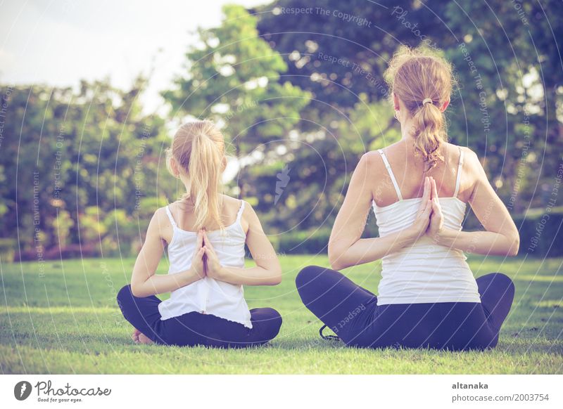 Mutter und Tochter tun Yoga-Übungen auf Gras im Park am Tag Zeit Lifestyle Freude Glück schön Körper Wellness stimmig Erholung Meditation Freizeit & Hobby
