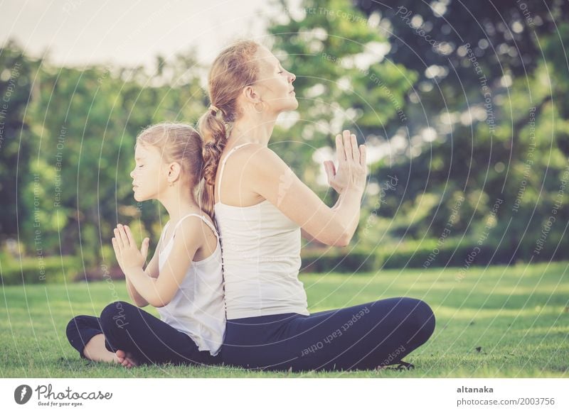 Mutter und Tochter tun Yoga-Übungen auf Gras im Park am Tag Zeit Lifestyle Freude Glück schön Körper Wellness stimmig Erholung Meditation Freizeit & Hobby