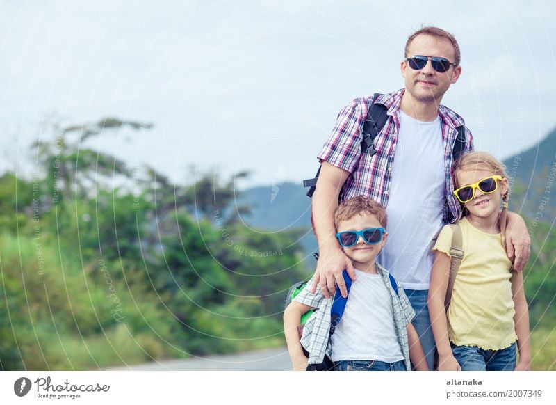 Vater und Kinder, die zur Tageszeit auf die Straße gehen. Lifestyle Gesundheit Ferien & Urlaub & Reisen Tourismus Ausflug Freiheit Sommer wandern Mensch Eltern