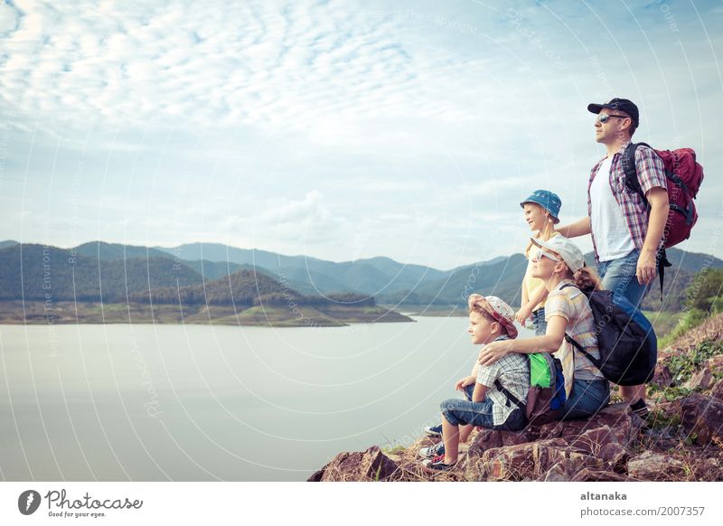 Glückliche Familie, die zur Tageszeit in der Nähe des Sees steht. Konzept der freundlichen Familie. Lifestyle Freude Freizeit & Hobby Ferien & Urlaub & Reisen