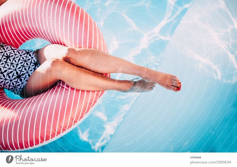 Frau, die auf aufblasbarem Ring im Swimmingpool sich entspannt Lifestyle Spa Schwimmbad Ferien & Urlaub & Reisen Sommer feminin Junge Frau Jugendliche