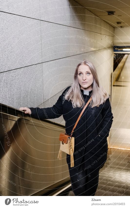 Junge Frau auf einer Rolltreppe Lifestyle elegant Stil Sightseeing Städtereise feminin Jugendliche 18-30 Jahre Erwachsene Stadt Bahnhof Mode Mantel Tasche blond