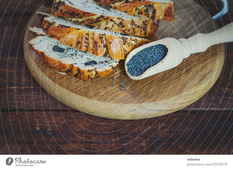 Brötchen mit Mohn auf einem Schneidebrett Brot Dessert Essen Löffel Holz frisch lecker braun schwarz süß Essen zubereiten Koch Korn Mehl Weizen backen