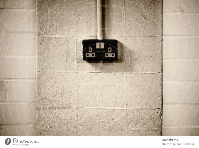 UK Power Supply Steckdose Wand schwarz Schwarzweißfoto Putzfassade Schalter Kabel Leitung Elektrizität Stromverbrauch England Englisch Ecke Mauerstein kahl