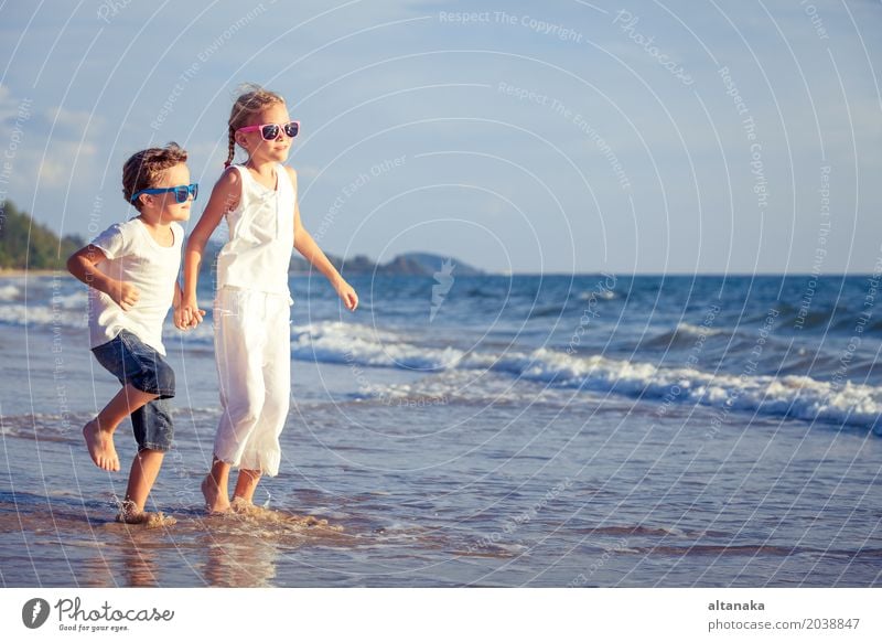 Glückliche Kinder, die auf dem Strand zur Tageszeit spielen. Lifestyle Freude Erholung Freizeit & Hobby Spielen Ferien & Urlaub & Reisen Abenteuer Freiheit