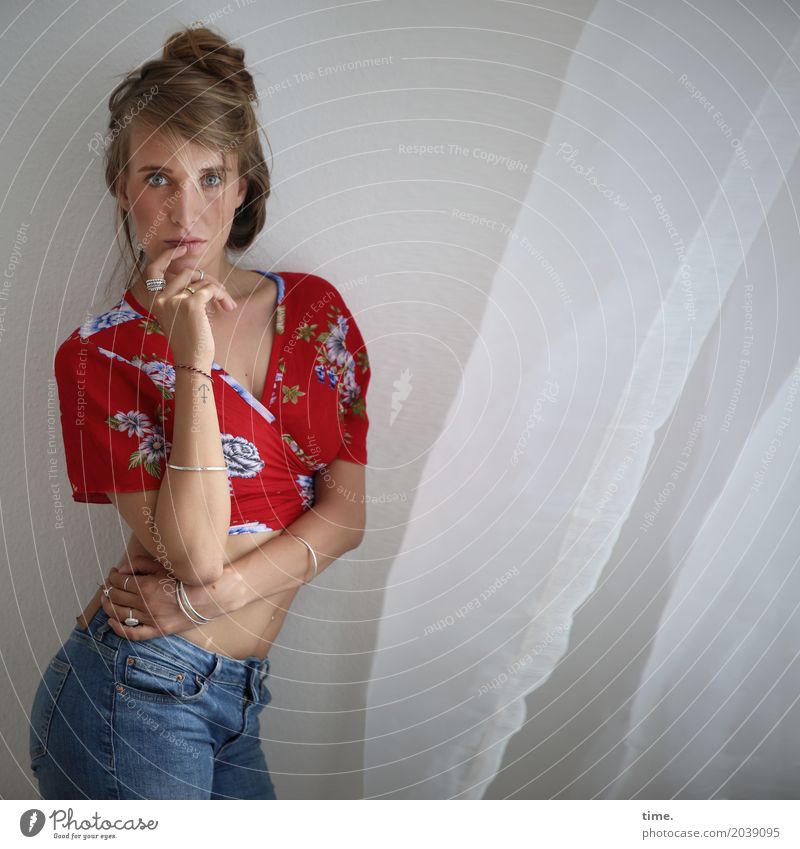 . Raum Vorhang feminin Frau Erwachsene 1 Mensch Hemd Jeanshose Schmuck blond langhaarig Zopf beobachten festhalten Blick stehen Neugier schön selbstbewußt
