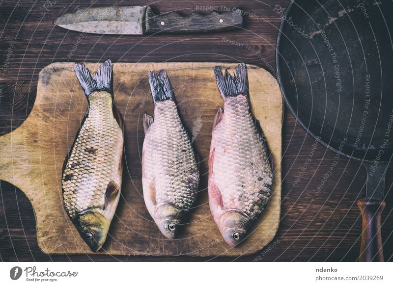 Fischkarpfen auf einem Küchenschneidebrett Lebensmittel Fleisch Kräuter & Gewürze Ernährung Pfanne Messer Tisch Holz Diät Essen frisch lecker natürlich oben