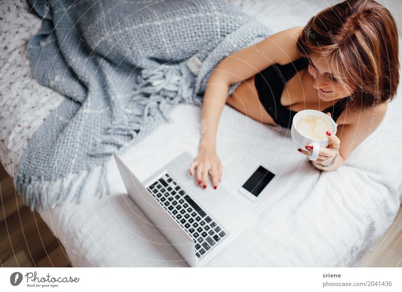 Trinkender Kaffee der jungen kaukasischen Frau im Bett mit Laptop trinken Lifestyle Glück Freizeit & Hobby Schlafzimmer lernen Computer Notebook
