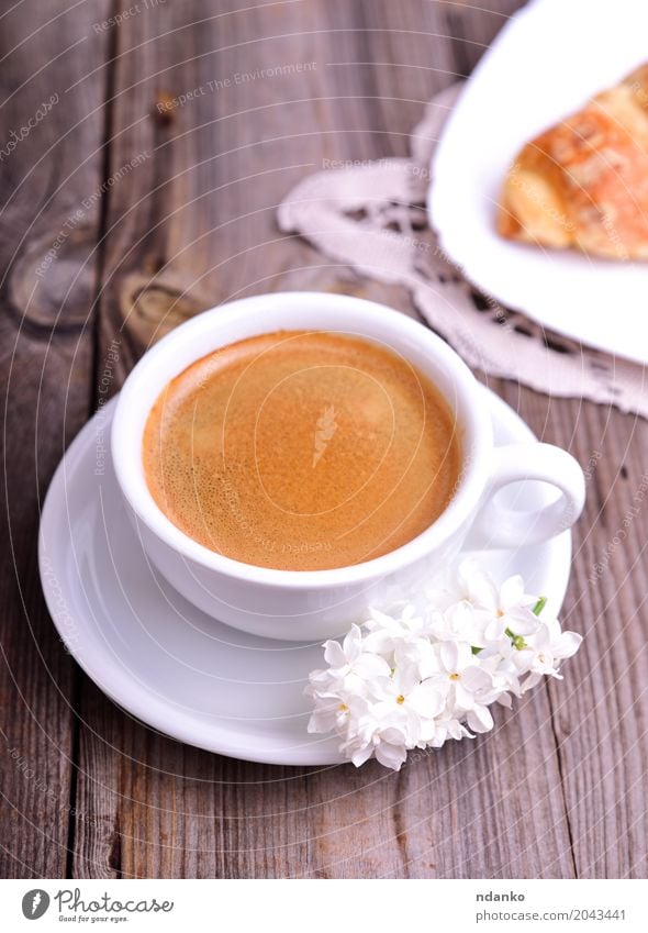 Schwarzer Kaffee in einer weißen Tasse Croissant Dessert Frühstück Espresso Becher Tisch Restaurant Blume Blumenstrauß Holz Essen frisch heiß oben retro braun