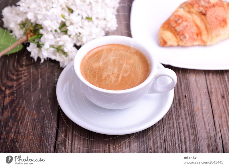 Schale heißer schwarzer Kaffee mit Hörnchen Croissant Frühstück Espresso Tisch Restaurant Blume Blumenstrauß Holz frisch lecker oben retro braun weiß Café
