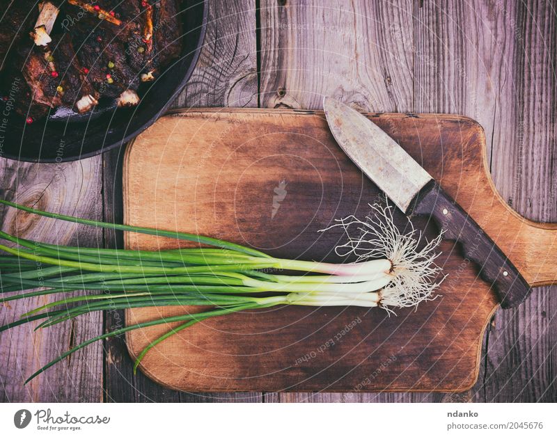 Frühlingszwiebel auf einem Küchenschneidebrett Fleisch Gemüse Pfanne Messer Holz Essen frisch oben grün Zwiebel Bratpfanne Top altehrwürdig Lebensmittel