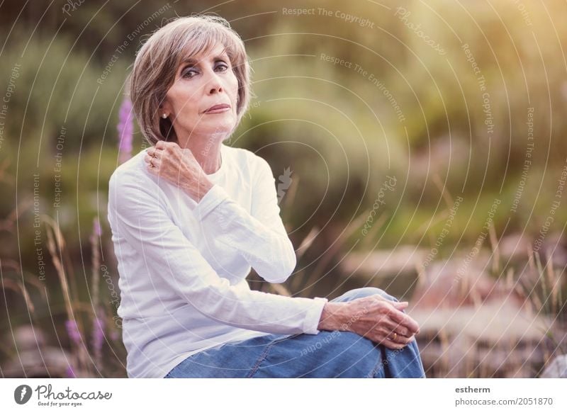 Glückliche ältere Frau, die auf dem Gras sitzt Lifestyle elegant Stil Wellness Leben Wohlgefühl Mensch feminin Erwachsene Weiblicher Senior Großeltern