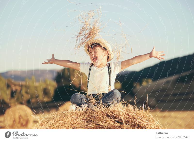 Kind spielt im Weizenfeld. Glückliches Kind auf einem Feld mit Ballenernte Lifestyle Freude Wellness Mensch maskulin Kleinkind Junge Kindheit 1 3-8 Jahre