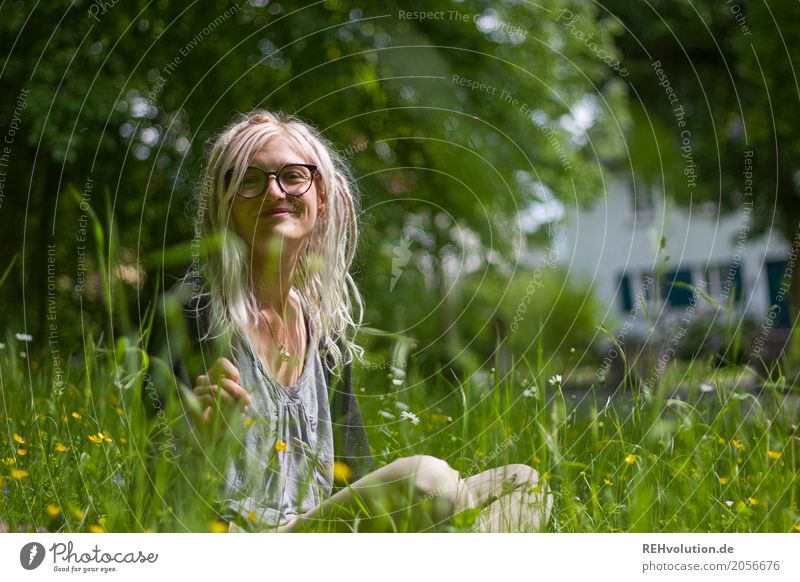 glückliche Junge Frau sitzt in einer Wiese Haare & Frisuren Natur Erwachsene Umwelt 18-30 Jahre Gesicht authentisch grün alternativ ökologisch trendy