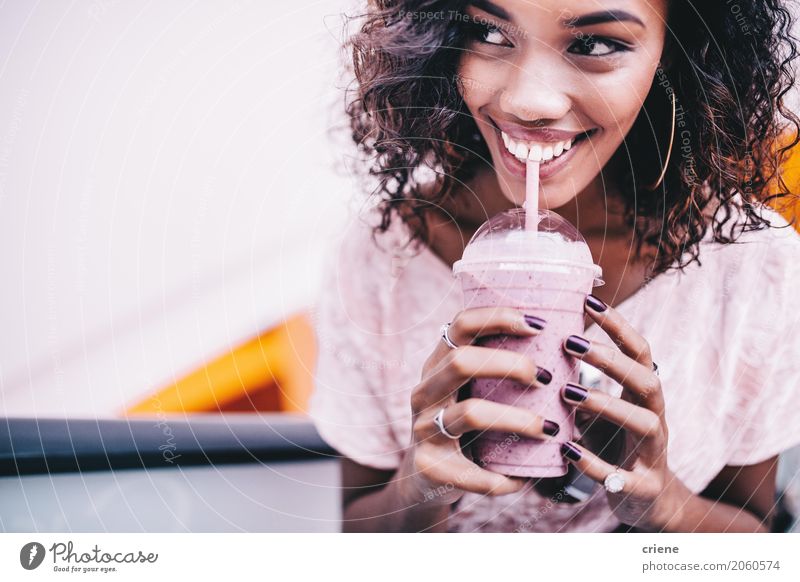 Glückliche Frau, die einen frischen Erdbeeresmoothie trinkt Frucht Getränk trinken Lifestyle schön Sommer feminin Junge Frau Jugendliche 1 Mensch Afro-Look