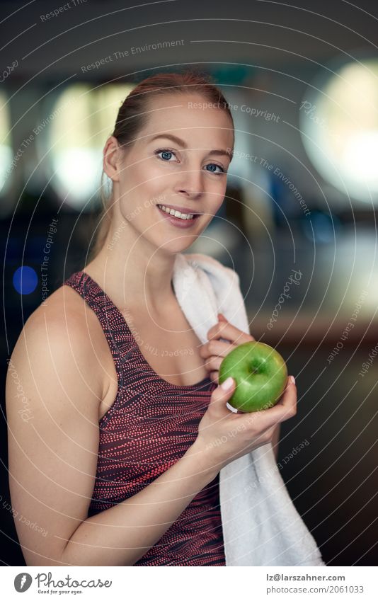 Attraktive junge Sportlerin, die einen Apfel anhält Frucht Diät Lifestyle Frau Erwachsene 1 Mensch 18-30 Jahre Jugendliche sportlich frisch natürlich Athlet