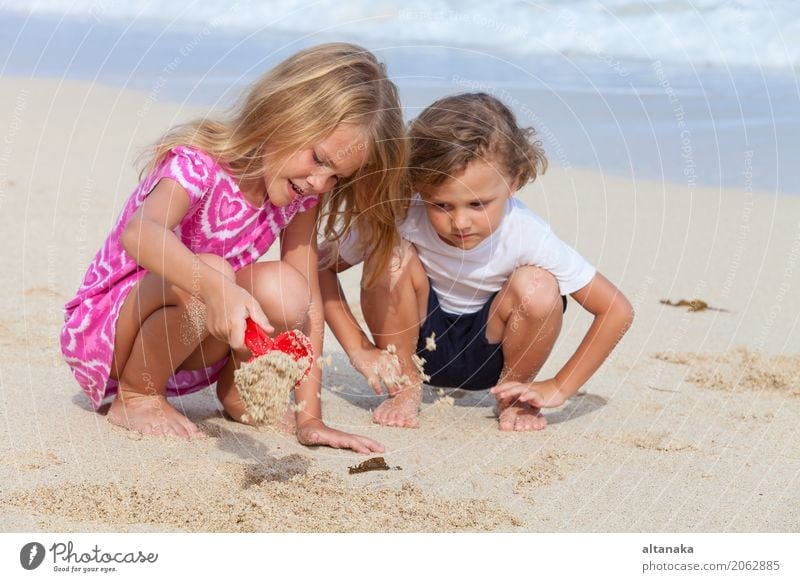 Zwei glückliche Kinder, die auf dem Strand spielen Lifestyle Freude Glück schön Erholung Freizeit & Hobby Spielen Ferien & Urlaub & Reisen Freiheit Sommer Sonne