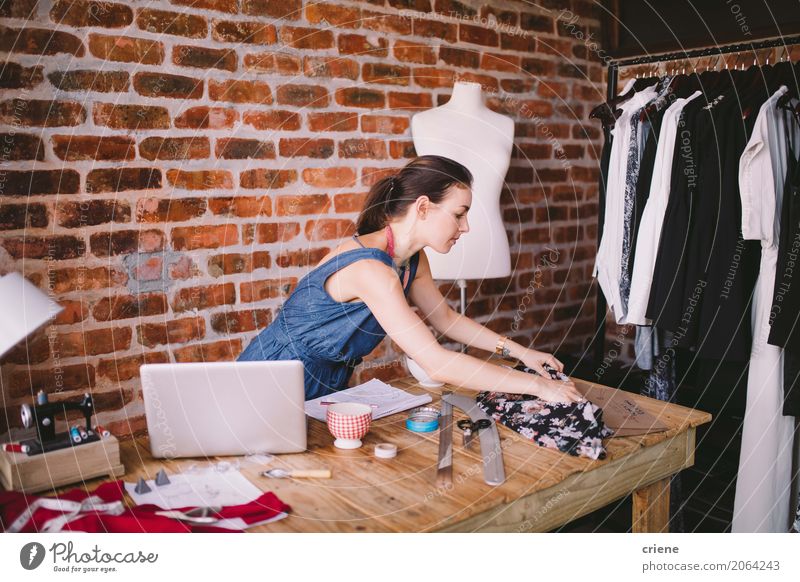 Junger weiblicher Modedesigner, der in ihrem Studio arbeitet Lifestyle Handarbeit Schreibtisch Arbeit & Erwerbstätigkeit Beruf Arbeitsplatz Büro Fabrik Business