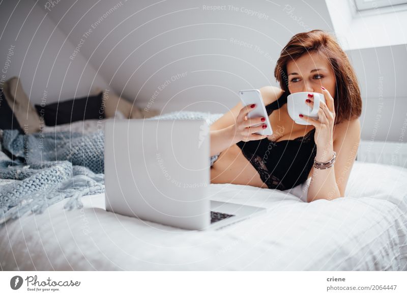 Frau Surfen mit Smartphone und Laptop im Bett trinken Kaffee Lifestyle Freizeit & Hobby Schlafzimmer lernen Telefon Handy PDA Notebook Technik & Technologie