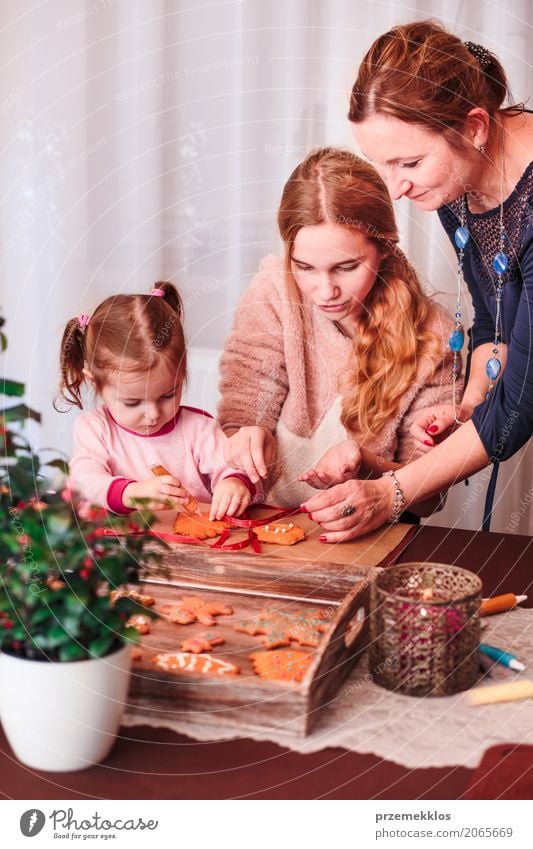 Familie, die Weihnachtslebkuchenplätzchen mit dem Zuckerguss verziert Dekoration & Verzierung Tisch Küche Feste & Feiern Kind Mensch Frau Erwachsene