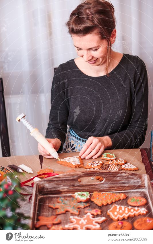 Frau, die gebackene Weihnachtslebkuchen mit dem Bereifen verziert Lifestyle Dekoration & Verzierung Tisch Küche Feste & Feiern Weihnachten & Advent Mensch