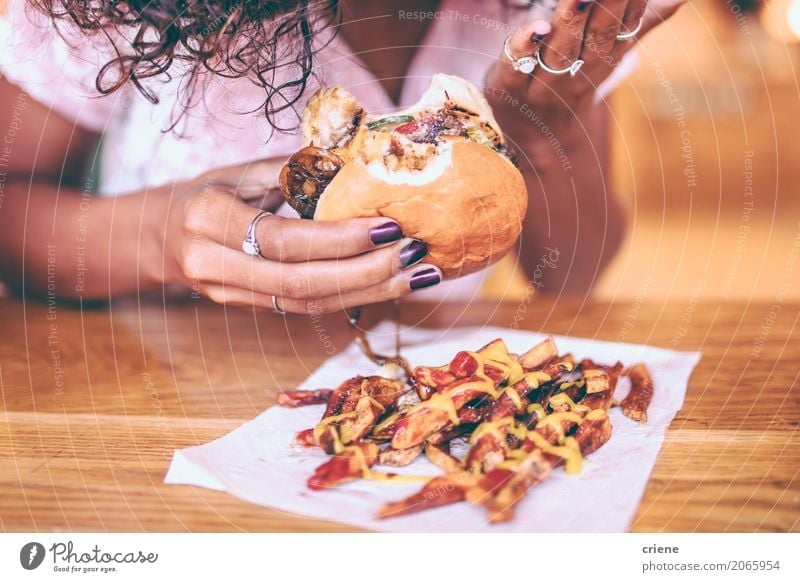 Nahaufnahme der Frau Pommes und Hamburger essend Fleisch Brot Brötchen Kräuter & Gewürze Essen Diät Fastfood Lifestyle Restaurant Erwachsene Afro-Look dick