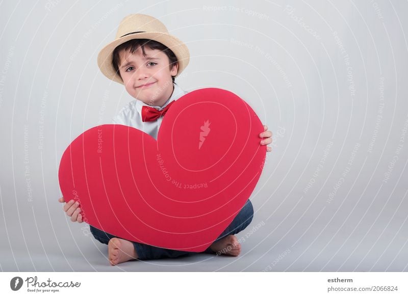 lächelnder Junge mit einem roten Herzen Lifestyle Freude Feste & Feiern Valentinstag Muttertag Mensch maskulin Kind Kleinkind Kindheit 1 3-8 Jahre Hut Küssen