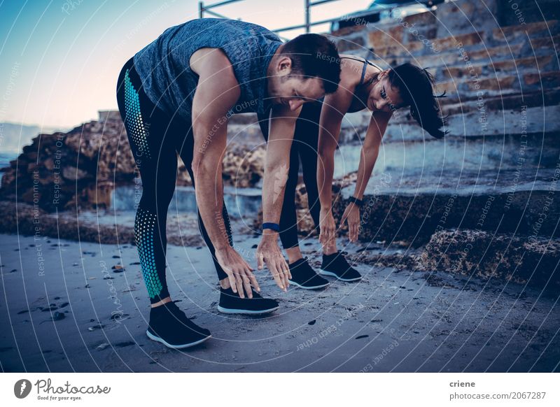 Junge Athletenpaare, die zusammen Übung ausdehnend tun Lifestyle Freude Glück Wellness Leben Wohlgefühl Freizeit & Hobby Strand Sport Mensch Frau Erwachsene
